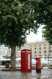 red telephone booth near green trees